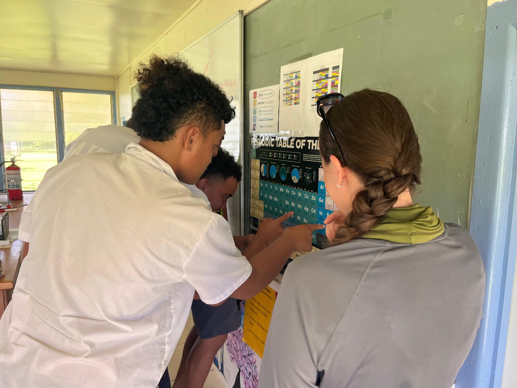 Cook Islands student and HISEAS field team member working with a periodic table during a classroom visit.